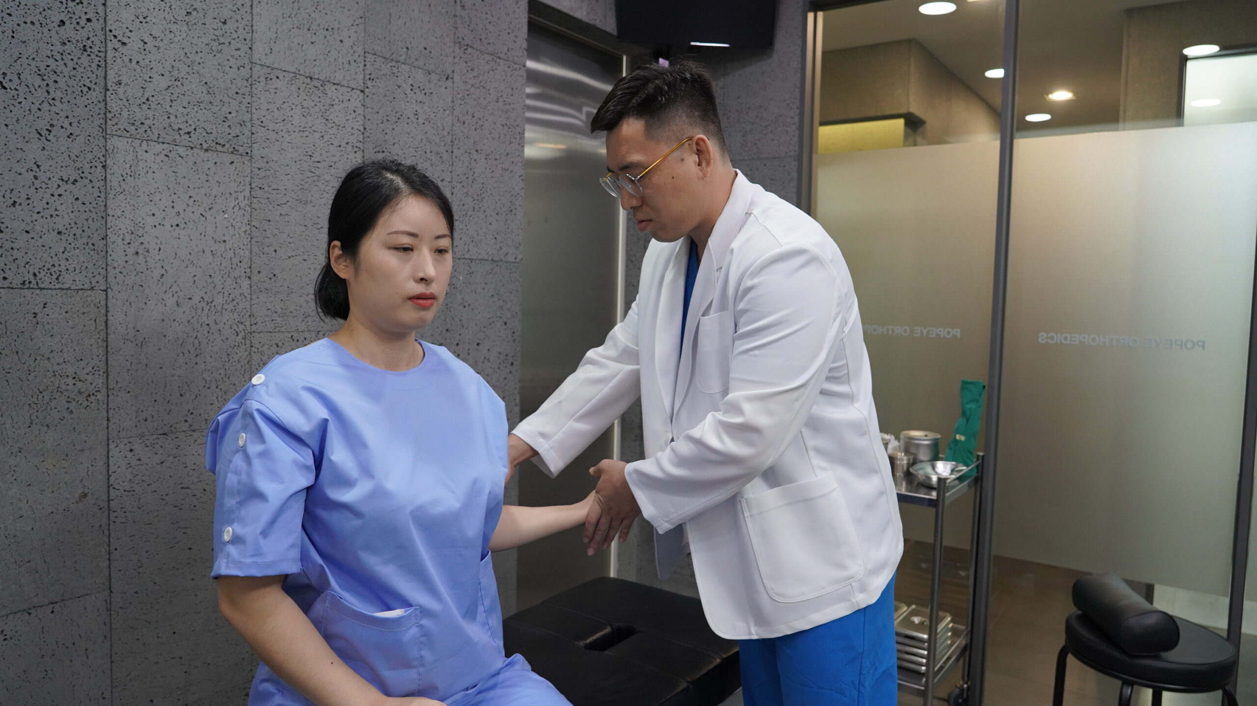 의료진이 환자의 팔과 어깨 움직임 범위를 확인하는 모습