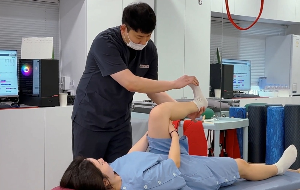 재활치료 과정에서 의료진이 환자의 다리와 고관절 움직임을 확인하는 모습