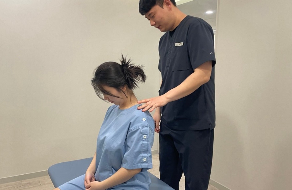 의료진이 환자의 목과 어깨 움직임을 확인하는 모습
